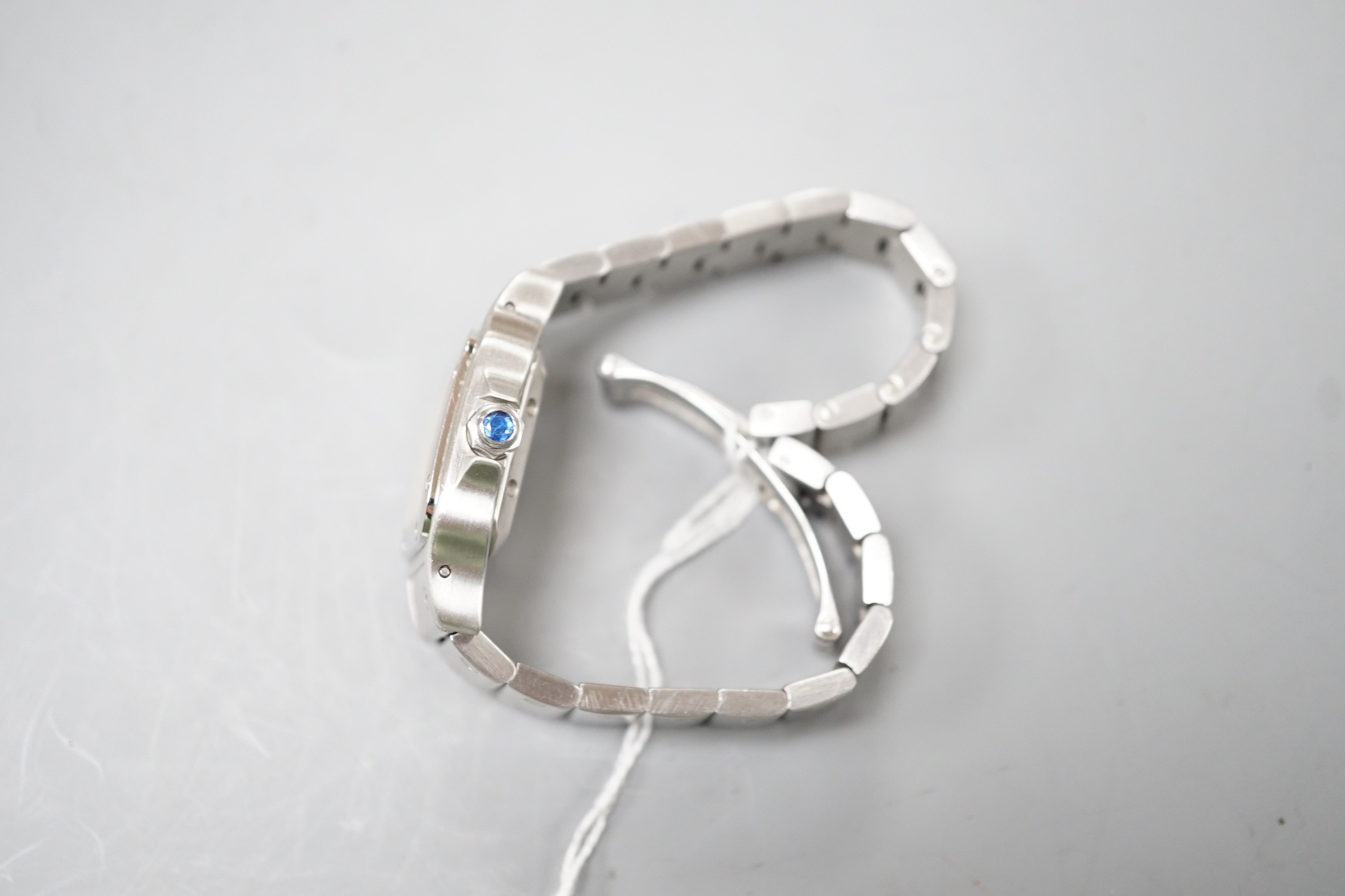 A lady's stainless steel Cartier Santos Automatic wrist watch, on stainless steel Cartier bracelet, with Roman dial and date aperture, no box or papers.